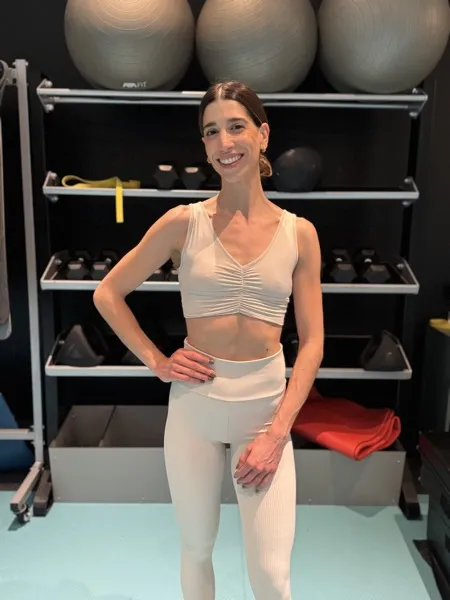 Nora smiling in the gym with training equipment